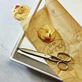Baking scene: biscuits, baking parchment, scissors, baking tray