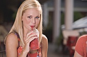 Junge Frau trinkt einen Frozen Strawberry Smoothie