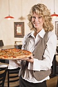 Blond woman holding a pizza