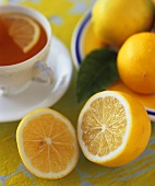 Tasse Tee mit ganzen und halbierter Zitrone