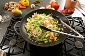 Vegetables in wok on hob, Asian ingredients behind