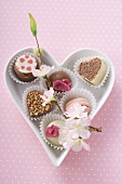 Several chocolates in a heart-shaped dish