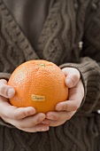 Girl holding organic orange