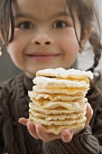 Girl holding a pile of rice crackers