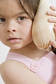 Girl listening to a sea shell