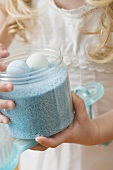 Girl holding container of bath products
