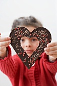 Girl looking through a chocolate heart
