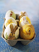 Mit Tiermotiven bemalte Ostereier im Eierkarton