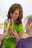 Junge Frauen stossen mit Champagner an