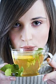 Young woman with lemon and mint tea