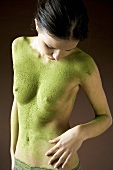 Junge Frau mit Körpermaske aus grünem Tee