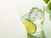 Mineral water with slice of lime and ice cube