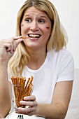 Junge Frau mit Deutschland-Farben im Gesicht isst Salzstangen