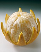 An orange, half-peeled
