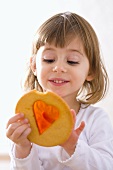 Small girl with window cookie (biscuit with sugar window)