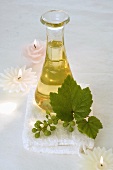 Grape seed oil from white grapes in a carafe with candles
