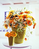 Chamomile, ranunculus, sunflowers and marigolds in vases