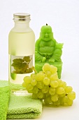 White grape seed oil, grapes and green Buddha candle