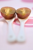 Two red grape halves on spoons