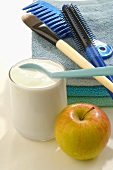 Yoghurt, apple, cosmetics brush, hairbrush and comb