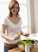 Frau bereitet Salat zu