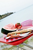 Tomaten-Mozarella-Sandwich und Wassermelone am Strand