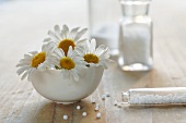 Homeopathic remedy (globuli) and chamomile flowers