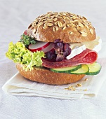 Oat roll filled with salami, Brie and salad