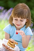 Kleines Mädchen hält Teller mit Apfel-Pancakes