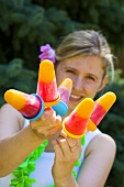 Woman holding colourful ice lollies at a party