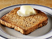Pat of Butter Melting on a Piece of Whole Grain Toast