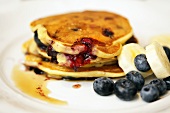 Pancakes with blueberries, bananas and maple syrup