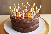 A chocolate birthday cake with lots of candles