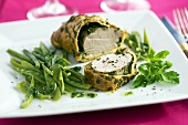 A pastry-wrapped pork fillet with herbs and mangetout