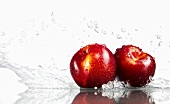 Two plums being washed