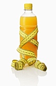 A bottle of orange juice with a tape measure