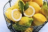 Organic lemons in a wire basket, one halved