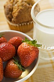 Strawberries, glass of milk and muffin for breakfast