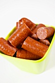 Pieces of Debreziner sausage in plastic bowl