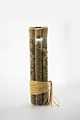 Assorted Dried Herbs in Glass Tubes; Tied on a White Background