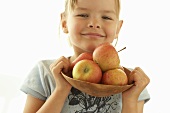 Small girl holding a bowl of apples