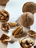 Whole and opened walnuts on white background