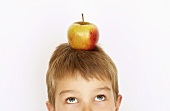 Small boy with apple on his head
