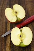 A halved apple with knife