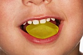 Child eating yellow wine gum