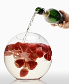Pouring sparkling wine into strawberry punch