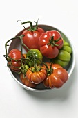 Red and green beefsteak tomatoes in a bowl