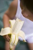 Small child eating a banana