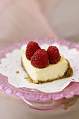 A piece of mini-cheesecake with raspberries