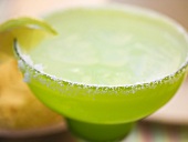 Limetten-Cocktail in grünem Glas